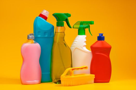 House cleaning detergent bottles on a yellow background, copy space