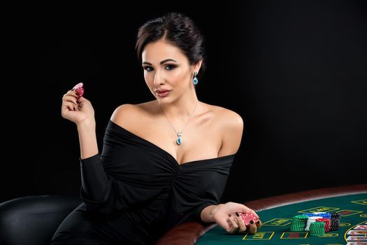 sexy woman with poker cards and chips. Female player in a beautiful black dress