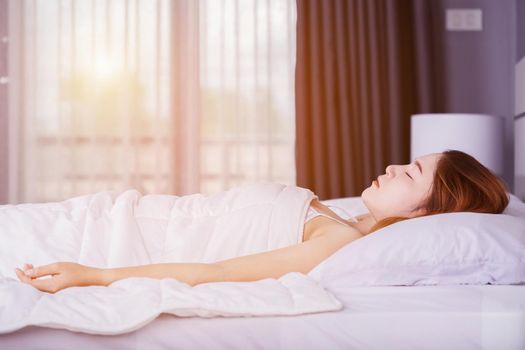 Woman sleeping on bed in bedroom with soft light