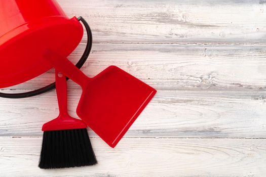 Red brush, scoop and bucket on wooden background, top view