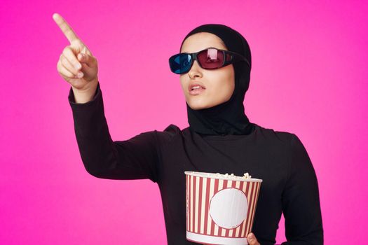 Muslim woman in 3D glasses popcorn entertainment movies model ethnicity. High quality photo