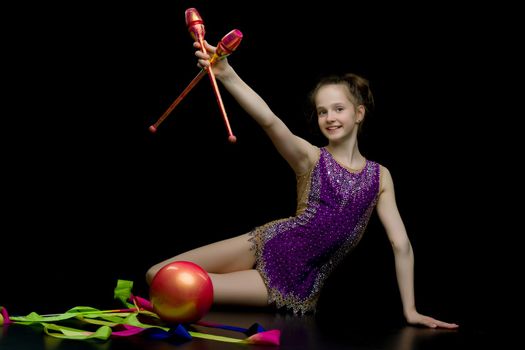 Beautiful little girl gymnast performs exercises with the ball. The concept of children's sports, fitness. Isolated.