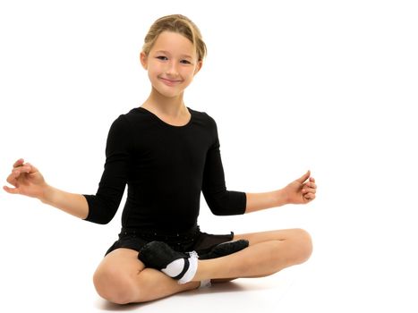 A sweet little gymnast girl performs an acrobatic element on the floor. The concept of sport, healthy lifestyle. Isolated on white background.