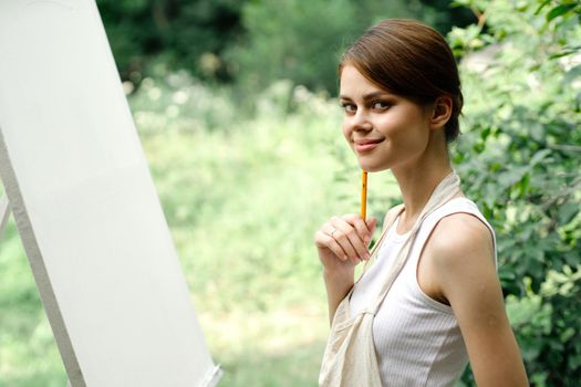 Cheerful woman artist nature easel creative art. High quality photo