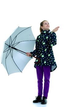 A cute little girl hid under an umbrella and held out her hand, She looks It is raining. The concept of changing the weather. Isolated on white background.