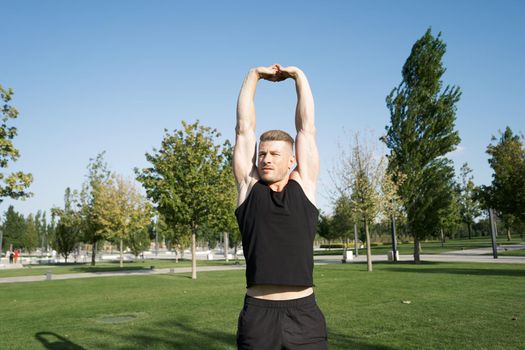 beefy man and athlete in the park during summer workout. High quality photo