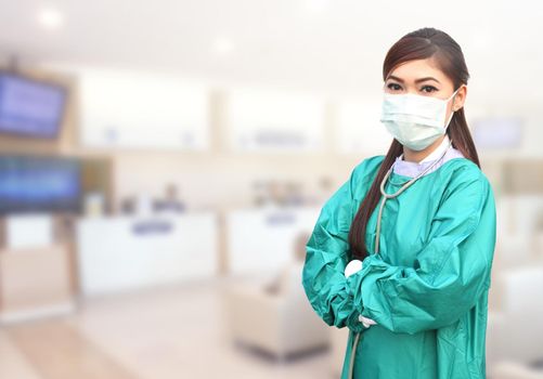 female doctor wearing a green scrubs and stethoscope in hospital background