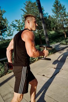 sporty man exercise fitness workout outdoors with dumbbells. High quality photo