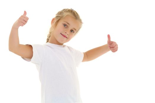 A beautiful little girl in an empty white T-shirt points to herself. The concept of design of T-shirts, advertising of children's goods. Isolated on white background.