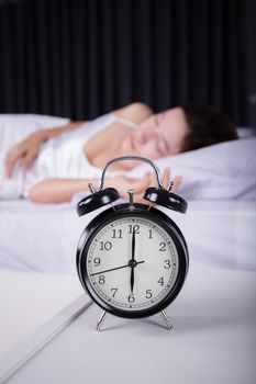 clock show 6 O'clock and woman sleeping on the bed 