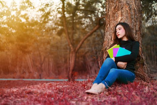 young woman holding a book in the park