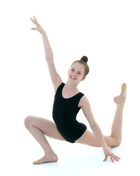 A sweet little gymnast girl performs an acrobatic element on the floor. The concept of sport, healthy lifestyle. Isolated on white background.