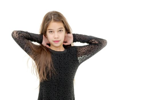 A charming little school girl corrects her long silky hair with her hands. The concept of style and fashion, happy people. Isolated on white background.