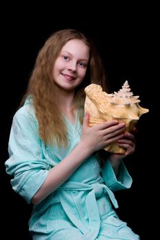 A little girl with a sea shell. The concept of a family vacation at sea, ecology. Isolated background.