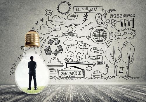 Businessman inside of light bulb in empty concrete room and sketches on wall