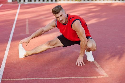 athletic man doing exercises outdoors sports field exercise. High quality photo