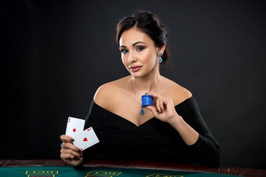 sexy woman with poker cards and chips. Female player in a beautiful black dress