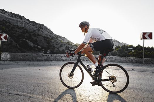 Professional road bicycle racer man in action on mountain road