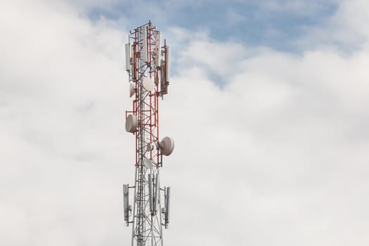 Mobile communication network communication tower with antens on the background of the sky.