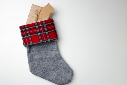 Christmas stocking with wrapped gift on white background top view