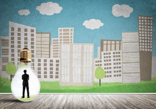 Businessman inside light bulb against city drawn concept