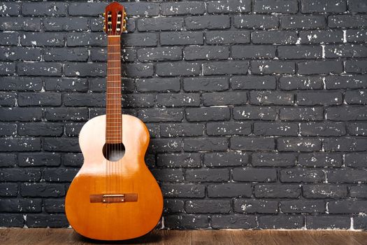 One guitar on the floor against white brick wall, copy space