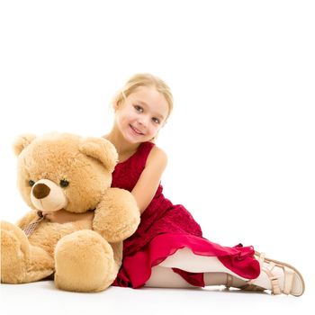 Little girl with a teddy bear. The concept of the game, raising a child in kindergarten and in the family. Isolated on white background.