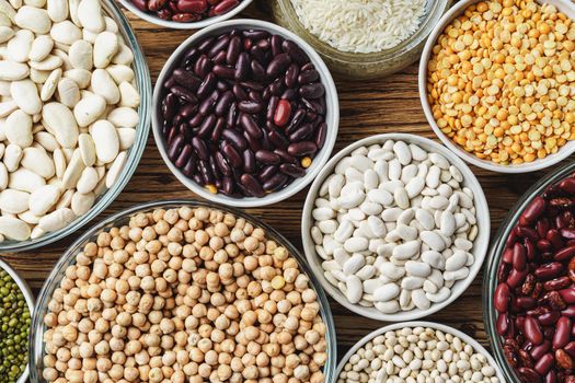 Assortment of beans on wooden background.