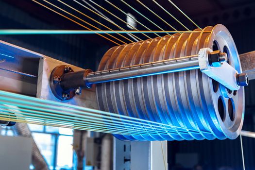 Inside a modern plant producing power electric cables and optical fibers. .Cable manufacturing machine part. Close up.