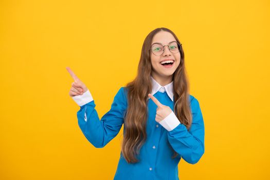 For best education of your child. Happy girl point fingers yellow background. School advertisement. Your school name, copy space.