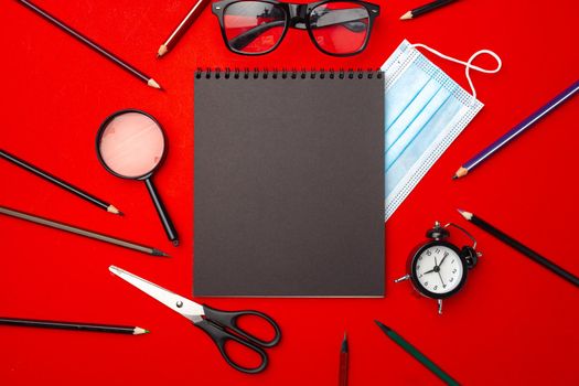 It's time to get back to school. Stationery and alarm clock top view