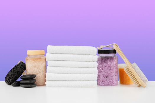 Bath towels and spa salt on white table, close up