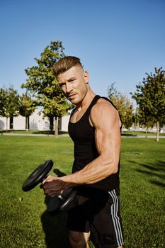 sporty man in black t-shirt in the park training lifestyle. High quality photo
