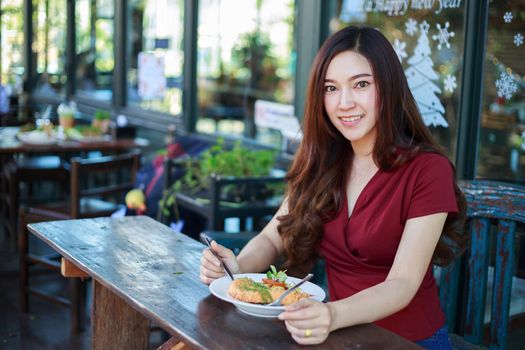 young woman eating food in a restaurant 