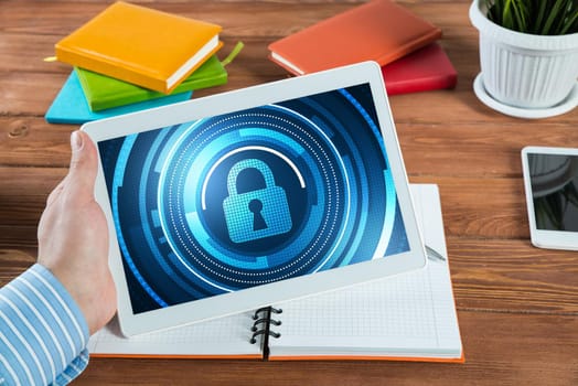 close-up, male hands with tablet. Businessman working at the table in office. computer security concept
