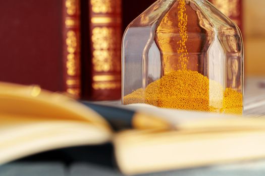 Golden sand hourglass close up on working table. Close up.