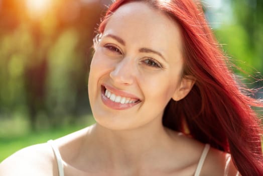 Portrait of a young attractive woman in the park. Smiling and happy
