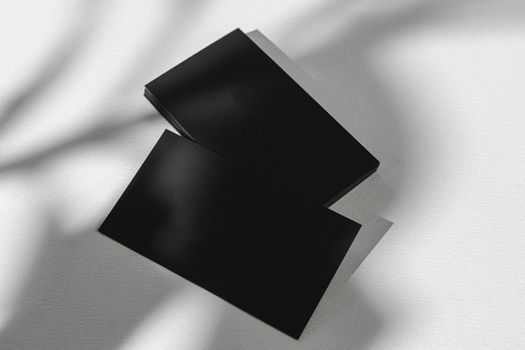 Foliage shadow on paper background with business card. Creative photo