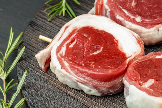 fresh meat with ingredients for cooking on dark background, close up
