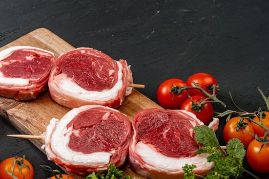 Raw beef steak on a dark wooden table