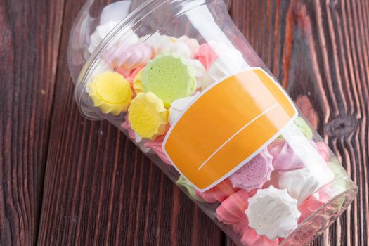 Colorful sweet meringue cookies assortment on wooden table close up
