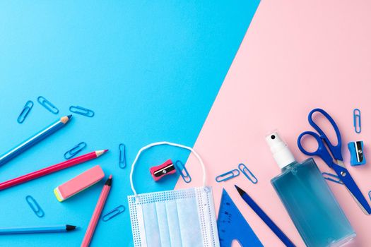 School stationery items and medical face mask, top view
