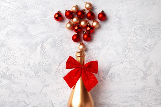 Flat lay composition with gold champagne bottle and Christmas balls top view