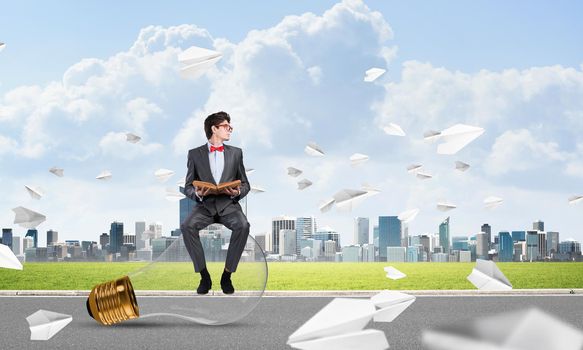 young businessman with a book. flying around paper plane in chaos