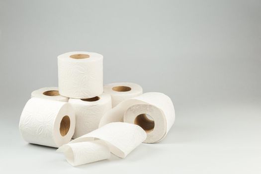 Rolls of White Toilet Paper over Gray Background. Copy Space for text