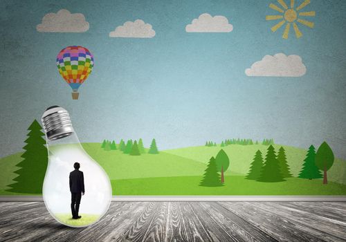 Businessman inside light bulb in room against nature drawn concept