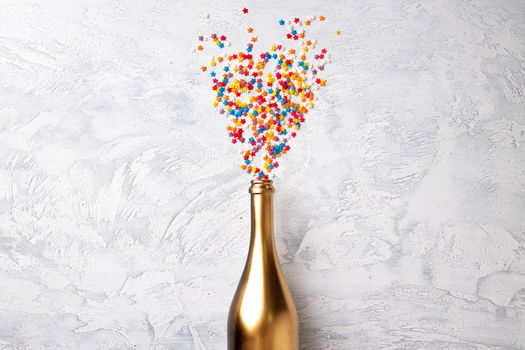 Champagne bottle with confetti flat lay top view, christmas background