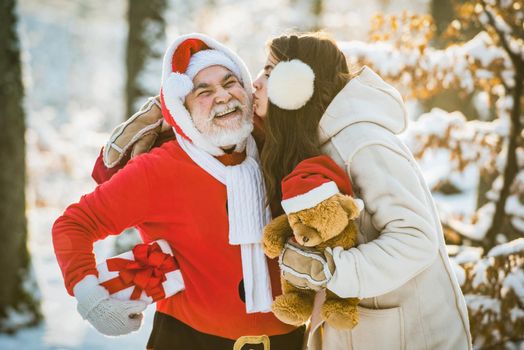 Wish you merry Christmas. Santa with winter girl on snow field. Winter funny people