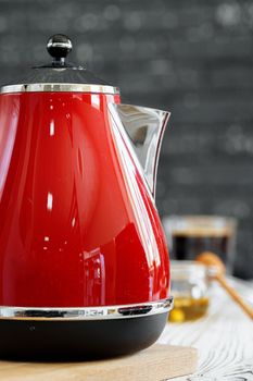 Red kettle on kitchen counter table close up
