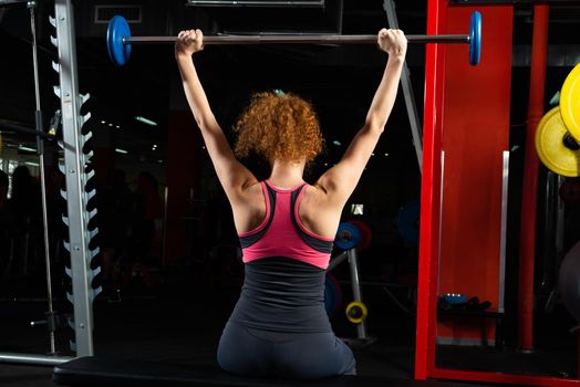 Woman bodybuilder engaged with a barbell in the gym. Healthy lifestyle.